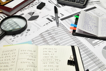 Top view of office employee's desk - work with financial reports, analysis and accounting, tables and graphs, various office items for bookkeeping