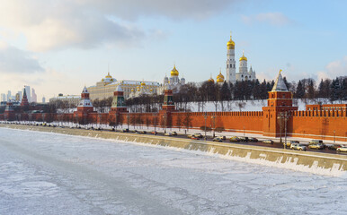 Obraz premium Cars on the Kremlin embankment and the frozen Moscow river on a clear winter day.