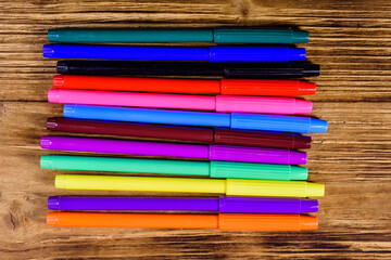 Fototapeta premium Multi colored felt tip pens on wooden table. Top view