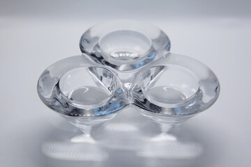 A transparent glass candlestick with a support base and the top of which has three nozzles where the candles are placed to light.