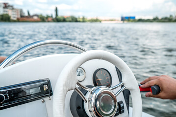 man drives a white motorboat on the river