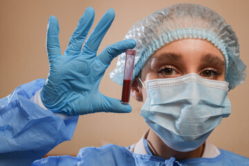 A doctor holds a test tube with a coronavirus positive blood sample. stop coronavirus. MERS....
