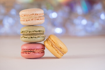 A vertical stack of three macarons against bright white background with an additional yellow macaron leaning inwards. 