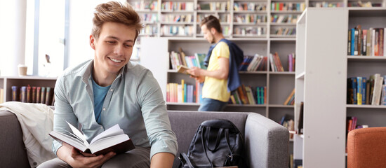 Young student on sofa in modern library, space for text. Banner design