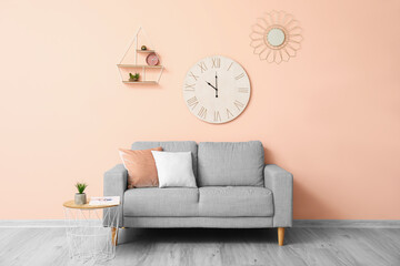 Stylish sofa near color wall in room