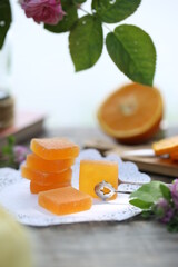 Sliced ​​orange, orange marmalade, book and a vase of flowers.
