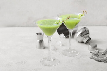 Glasses of tasty cucumber martini on white background