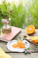 Sliced ​​orange, orange marmalade, book and a vase of flowers.
