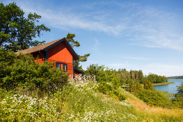 Red summer garden cottage in Sweeden. Traditional Sweden wooden old house. Life on the one of Sweeden islands