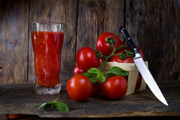 Fresh juice from tomatoes. Basket with tomatoes and a kitchen knife.