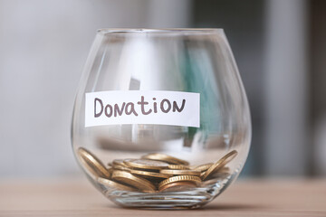 Glass bowl with money on table in room. Donation concept