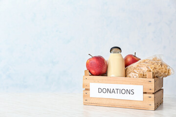 Box with donations on light background
