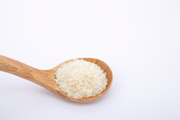 View of pile of rice in wooden spoon.