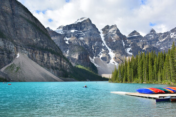 The scenery around Moraine Lake with colorful kayaks from boat house