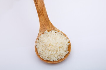 View of pile of rice in wooden spoon.