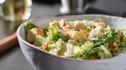 Fotobehang fresh caesar salad with croutons and parmasan cheese in bowl © Joshua Resnick
