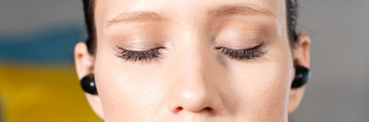 Close up portrait of attractive relaxed young woman meditating at home. Girl with eyes closed