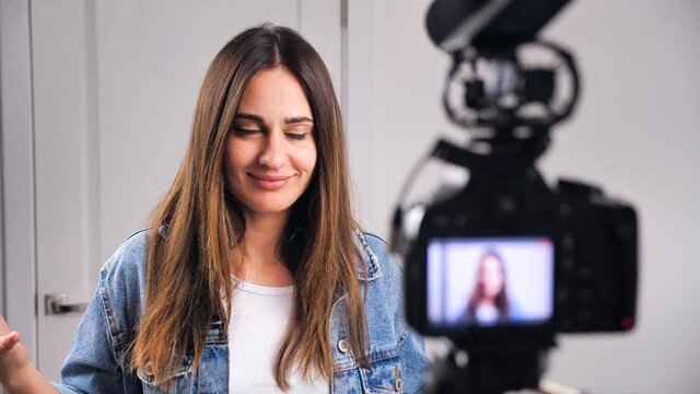 Blurry silhouette woman looking at the camera recording video at Home. Female smiles and is embarrassed