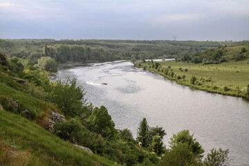 Top view of the river with a fast-moving motorboat with tourists in a nature reserve. Fishermen sail on the ship for the catch. Beautiful pretty landscape. Stock photo