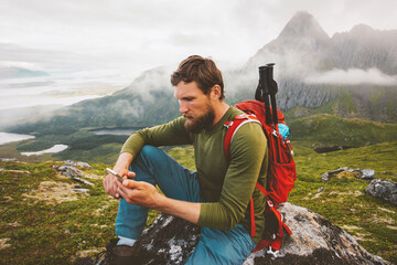 Man hiker using smartphone application navigation in mountains travel blogger influencer lifestyle...