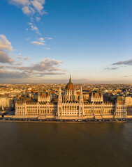 Aerial drone view of Hungarian Parliament facade by danube river in Budapest sunset hour