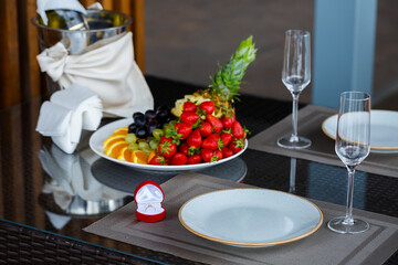 Engagement gold precious jewelry ring for a girl in a red box on a background of fruit