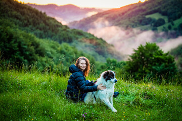 Naklejka na ściany i meble woman and dog in amazing summer landscape at sunset