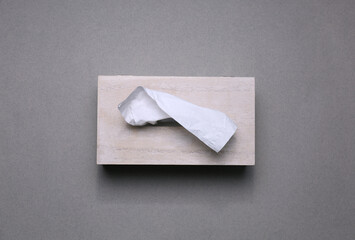 Holder with paper tissues on grey background, top view
