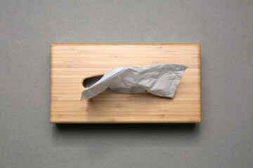Holder with paper tissues on grey background, top view