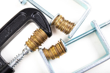 Coins squeezed in a carpenter's clamp. The image of the European currency in crisis.