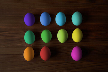 Colorful eggs for Easter on a wooden table. View from above.