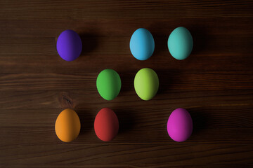 Colorful eggs for Easter on a wooden table. View from above.