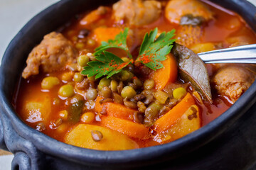 Traditional clay pot containing a lentil stew - macro