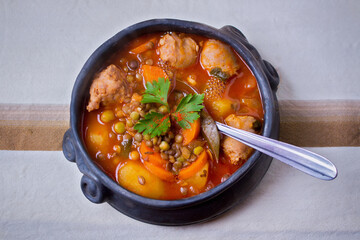 Traditional clay pot containing a lentil stew - tablecloth top