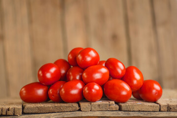 Summer agriculture fresh plum tomatoes. Group of paste tomatoes. Fresh long tomato on a wooden table