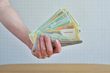Woman's hand holding dollar and euro bills