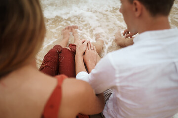 Beautiful young couple holding each other's hands with engagement ring
