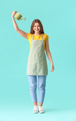 Young woman with watering can on color background