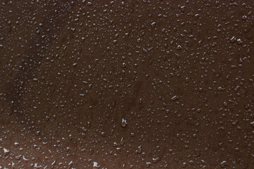 water drops on a brown metal surface, top view, for background. rain drips on the surface