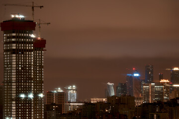 The construction of a high-rise building in the city. Moscow apartments at night. Moscow City. Moscow, Russia.