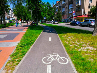 Empty bicycle lane on a busy city street on a summer sunny day. Bicycle sign on the road. Healthy...