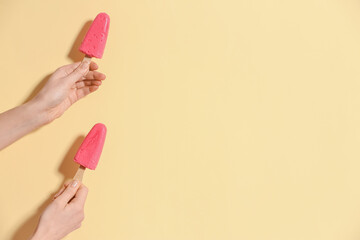 Hands with tasty strawberry ice cream on color background