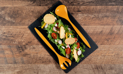 Fresh salad of arugula, pepper, radish, tomato and chips.