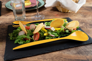 Fresh salad of arugula, pepper, radish, tomato and chips.
