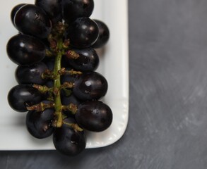 black grapes on a white  plate