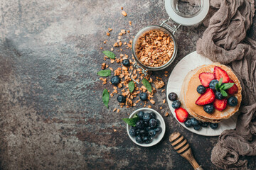 Fototapeta na wymiar American pancakes with fresh berry and granola on metal background. Summer homemade breakfast.