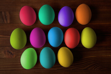 Colorful eggs for Easter on a wooden table. View from above.