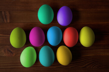 Colorful eggs for Easter on a wooden table. View from above.