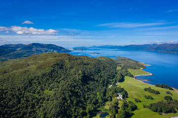 aerial image of loch linnhe on the west coast of the argyll and lochaber region of scotland near kentallen and duror showing calm blue waters and clear skies with green forest coast line