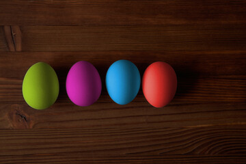 Colorful eggs for Easter on a wooden table. View from above.